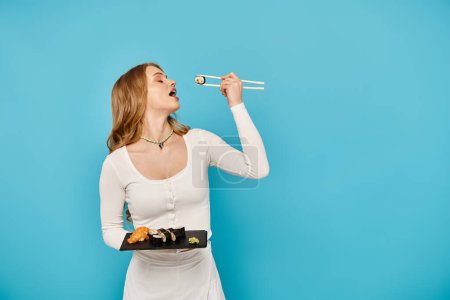 A beautiful woman in a white dress elegantly holds a tray of delicious Asian food.