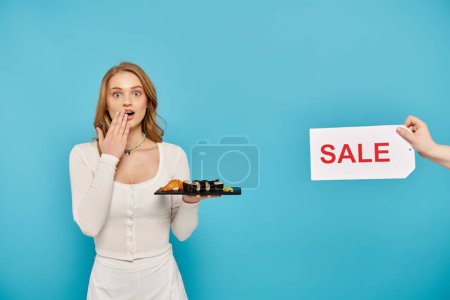 A stylish woman holds tray of sushi in front of a sale sign
