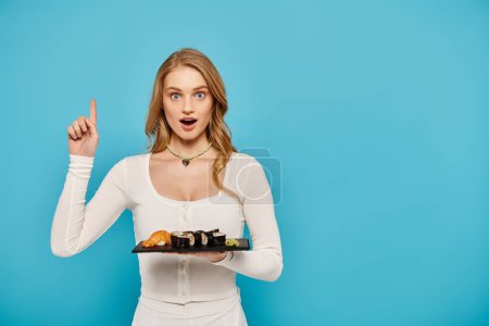 A beautiful blonde woman elegantly holding a tray filled with delicious Asian dishes.