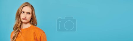 Photo for A young girl with a radiant smile dressed in an orange shirt confidently poses for the camera. - Royalty Free Image