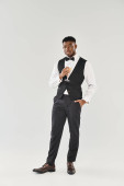 Suave man in tuxedo gracefully holds a champagne glass, radiating sophistication and charm. puzzle #699977884