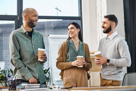 A group of coworkers standing around a table, engaging in a discussion over cups of coffee during a break in the office.