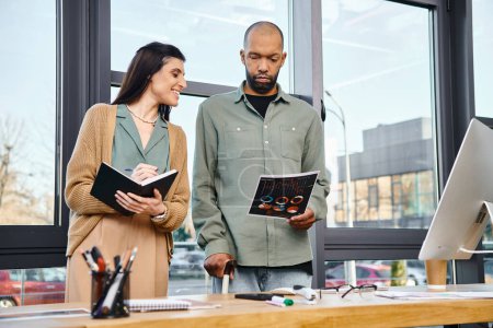 A man and a woman, both professionally dressed, brainstorming in front of a computer in a modern office space.