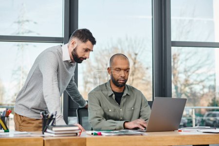 Dos hombres comprometidos en el trabajo colaborativo en un ordenador portátil en un entorno de oficina profesional, centrado y productivo, diversidad e inclusión