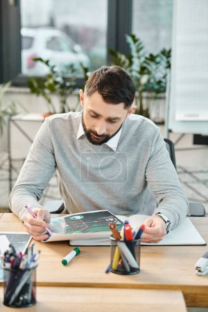 Ein arbeitsversessener Mann sitzt an einem Tisch mit einem Tablet im Büro eines Unternehmens.