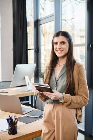 A businesswoman standing at a desk, holding a tablet in a bright office setting, immersed in corporate culture.