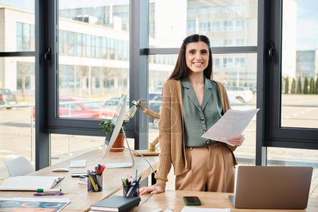 Photo for A professional woman standing at a desk with a laptop, immersed in a corporate project in a modern office setting. - Royalty Free Image