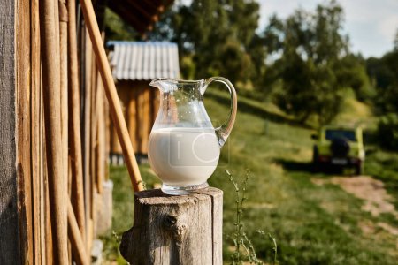 Objektfoto eines großen Glases frischer, schmackhafter Milch, das außerhalb des nahe gelegenen Dorfhauses auf einem modernen Bauernhof platziert wurde