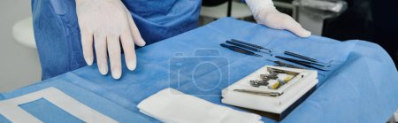 Photo for A doctor in a hospital gown and gloves preparing tools. - Royalty Free Image