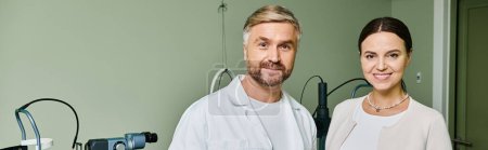 Photo for A man stands beside a woman in a hospital room. - Royalty Free Image