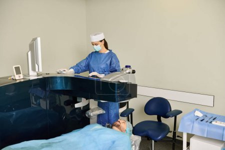 Téléchargez les photos : Médecin dans les gommages effectuant une chirurgie à l'aide d'un ordinateur dans un cadre médical. - en image libre de droit