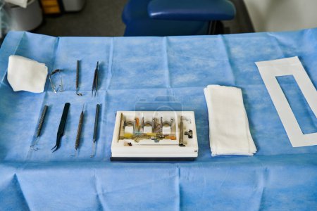 Une table est installée avec du matériel chirurgical sur une nappe bleue.