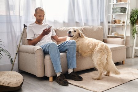 Ein afroamerikanischer Mann mit Myasthenia gravis sitzt auf einer Couch neben seinem treuen Labrador-Hund zu Hause in einem Moment der Inklusivität und Verbundenheit.