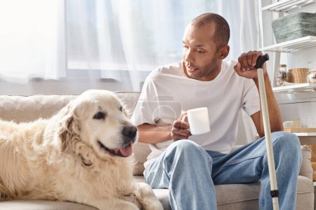 Ein Mann mit Myasthenia gravis sitzt auf einer Couch und genießt Gesellschaft mit seinem treuen Labrador-Hund in gemütlicher Wohnzimmeratmosphäre.