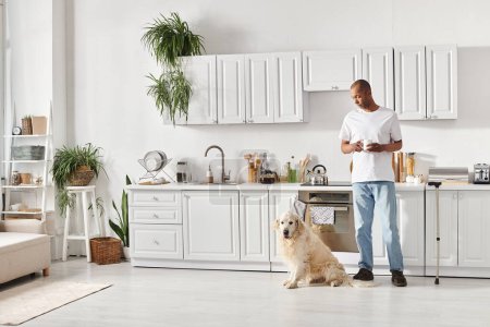 African American man with myasthenia gravis stands in kitchen with Labrador, showcasing diversity and inclusion.