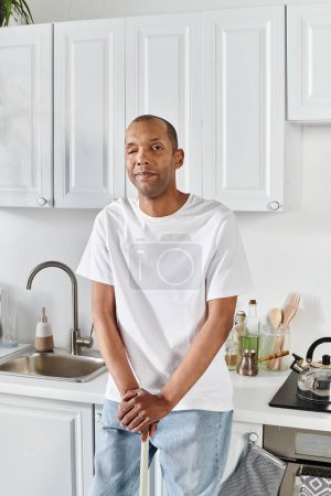 Ein afroamerikanischer Mann mit Myasthenia-gravis-Syndrom steht selbstbewusst in einer Küche