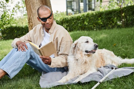 Photo for A myasthenia gravis syndrome man reading a book with his loyal Labrador dog by his side in a serene grassy setting. - Royalty Free Image