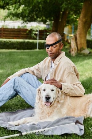 An African American man with myasthenia gravis syndrome sits in the grass with his loyal Labrador dog, embracing nature and each others company.