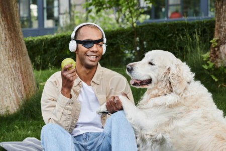 An African American man with myasthenia gravis wears headphones next to his loyal Labrador dog, embodying diversity and inclusion.