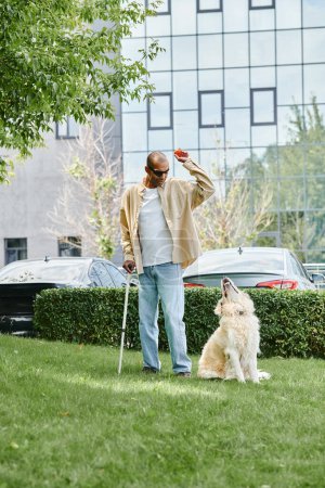 Foto de Un hombre afroamericano con miastenia gravis se encuentra junto a un perro labrador en un exuberante campo verde, encarnando la diversidad y la inclusión. - Imagen libre de derechos