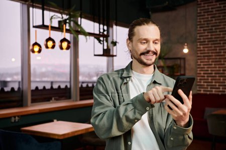 Ein Mann, der beim Essen in einem Restaurant in sein Smartphone vertieft ist