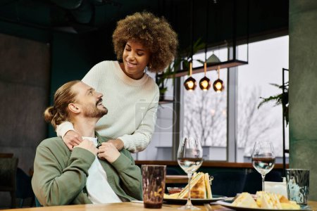 Eine afroamerikanische Frau und ein Mann unterhalten sich an einem Tisch im Café.