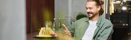 Ein Mann genießt freudig eine köstliche Mahlzeit auf einem Tisch in einem modernen Café, umgeben von einer geschäftigen Atmosphäre.
