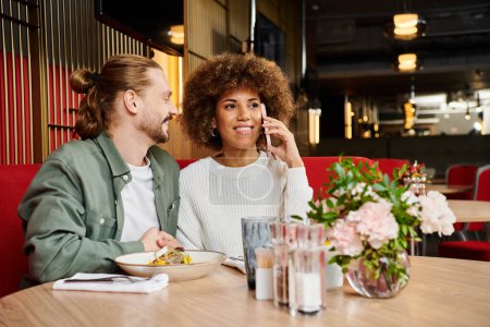 Eine afroamerikanische Frau und ein Mann an einem modernen Cafétisch