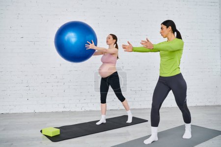 A pregnant woman and her coach doing exercises with a ball during parents courses.