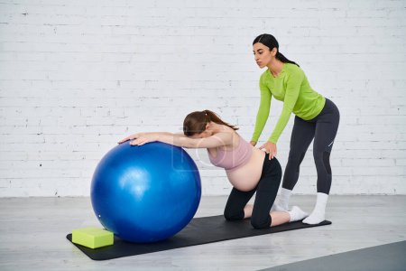 A pregnant woman is doing exercises on an exercise ball with her coach during parents courses.