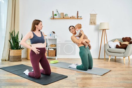 Una madre joven sostiene con gracia a su bebé mientras está de pie en una esterilla de yoga durante una sesión de curso de padres en casa.