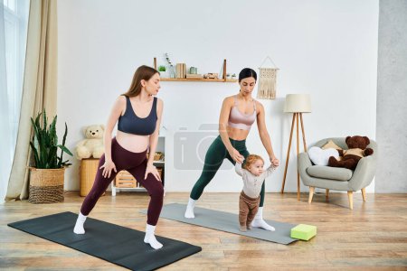 A young mother and her baby practice yoga in their cozy living room under the guidance of their instructor.