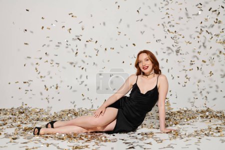Photo for Woman in black dress, seated gracefully - Royalty Free Image