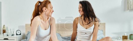 Téléchargez les photos : Deux femmes élégantes assises sur un lit engagé dans une conversation profonde. - en image libre de droit