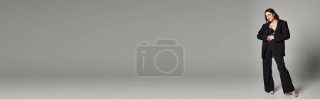 Foto de Una hermosa mujer de talla grande posa con un atuendo elegante contra un fondo gris. - Imagen libre de derechos