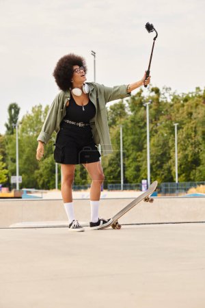 Une jeune Afro-Américaine avec un afro volumineux tenant en toute confiance un selfie stick et une planche à roulettes dans un skate park extérieur.