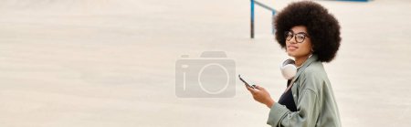 Una mujer elegante con un peinado afro usando un teléfono celular. La escena urbana captura su esencia mientras se conecta con la tecnología.