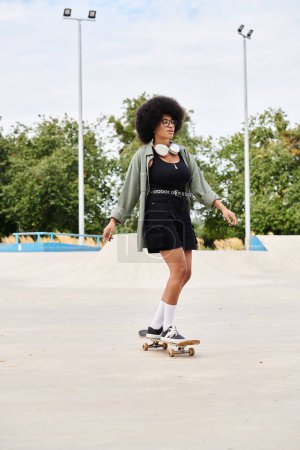 A skilled young African American woman with curly hair skateboards gracefully on top of a cement field in a skate park.