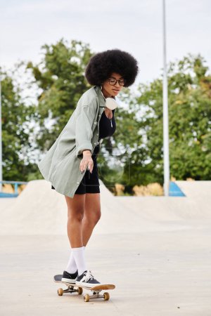A young African American woman with curly hair skateboarding on a cement surface in a skate park.