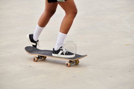 A young African American woman effortlessly rides a skateboard on a cement surface in a vibrant skate park.
