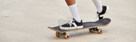 Junge Afroamerikanerin skateboardet auf einer Betonfläche in einem lebhaften Outdoor-Skatepark.
