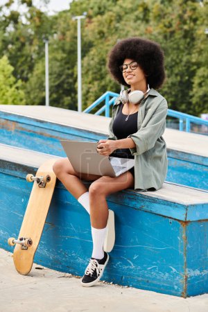 A young African American woman with curly hair sitting on a bench with her skateboard at an outdoor skate park.