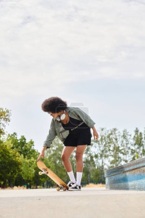 African American woman with curly hair glides on skateboard in a sleek black dress at an outdoor skate park.