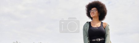 A vibrant woman with an afro standing gracefully in a lush field, exuding confidence and freedom.