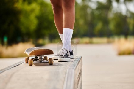Eine junge Afroamerikanerin fährt auf einem Skateboard auf einer Rampe in einem Skatepark und zeigt ihr Können.