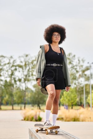 Una joven afroamericana se para con confianza en un monopatín en un parque de skate, mostrando sus habilidades y estilo.