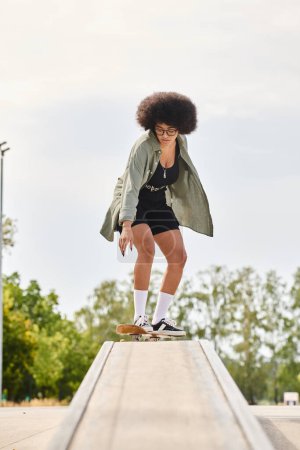 A young African American woman with curly hair skillfully rides a skateboard on a ledge at an urban skate park.