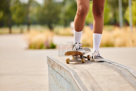 Una joven afroamericana patinando en una cornisa en un parque de skate al aire libre.