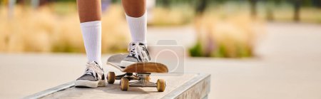 Photo for A young African American woman confidently rides a skateboard on a ramp at a skate park. - Royalty Free Image