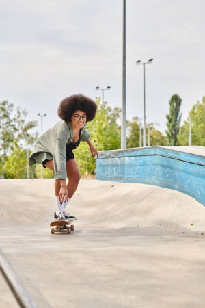 Eine junge Afroamerikanerin mit lockigem Haar skatet anmutig eine Rampe in einem Outdoor-Skatepark hinunter.